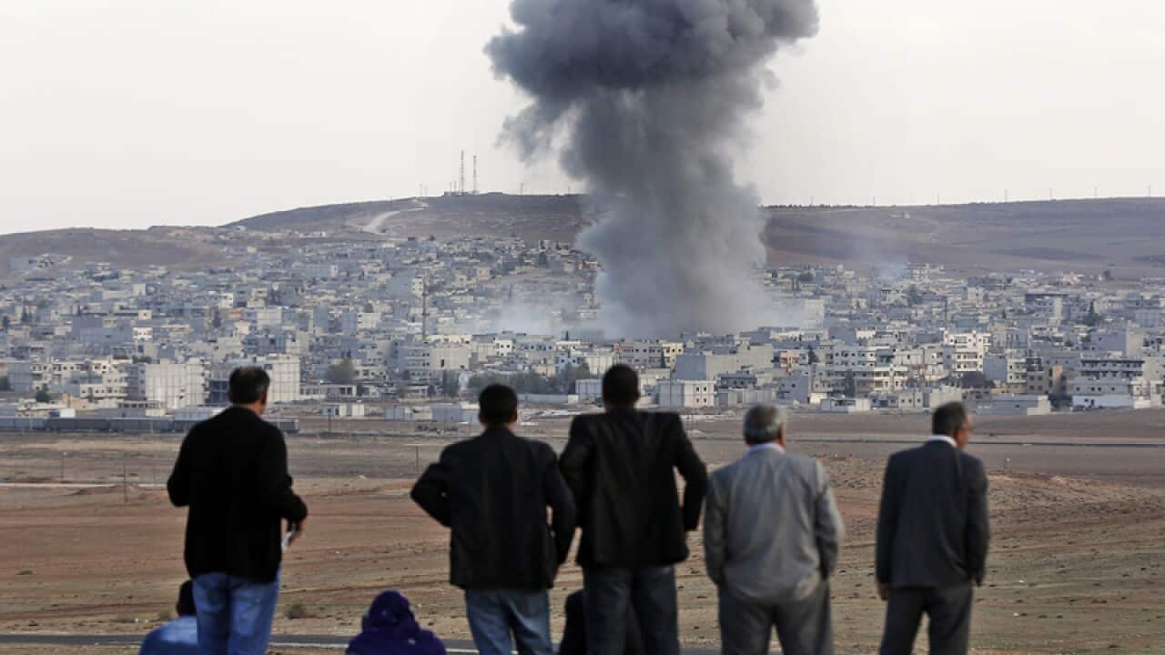 locals watching smoke rising over the Syrian city of Kobane