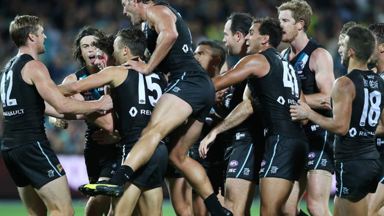 Port Adelaide players celebrate after kicking a goal