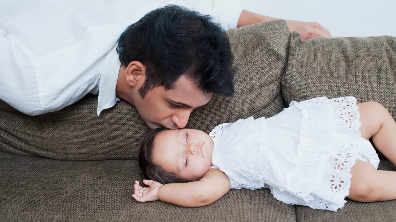 Man kissing his sleeping daughter