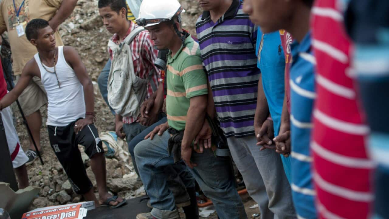 Honduran miners pray for eight of their fellow coworkers.