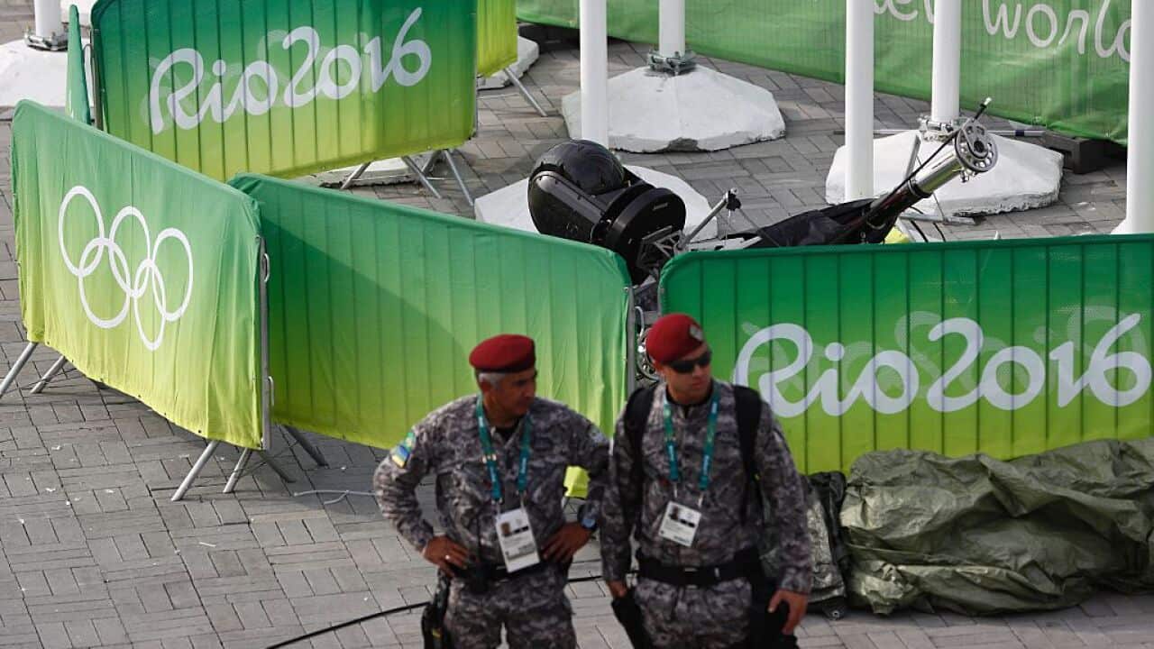 Members of the military stand guard by a television camera that fell to the ground in the Olympic park during the Rio 2016 Olympic games in Rio 