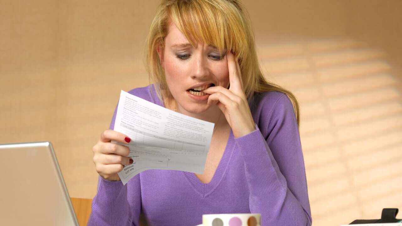 Teenager showing anxiety holding bill