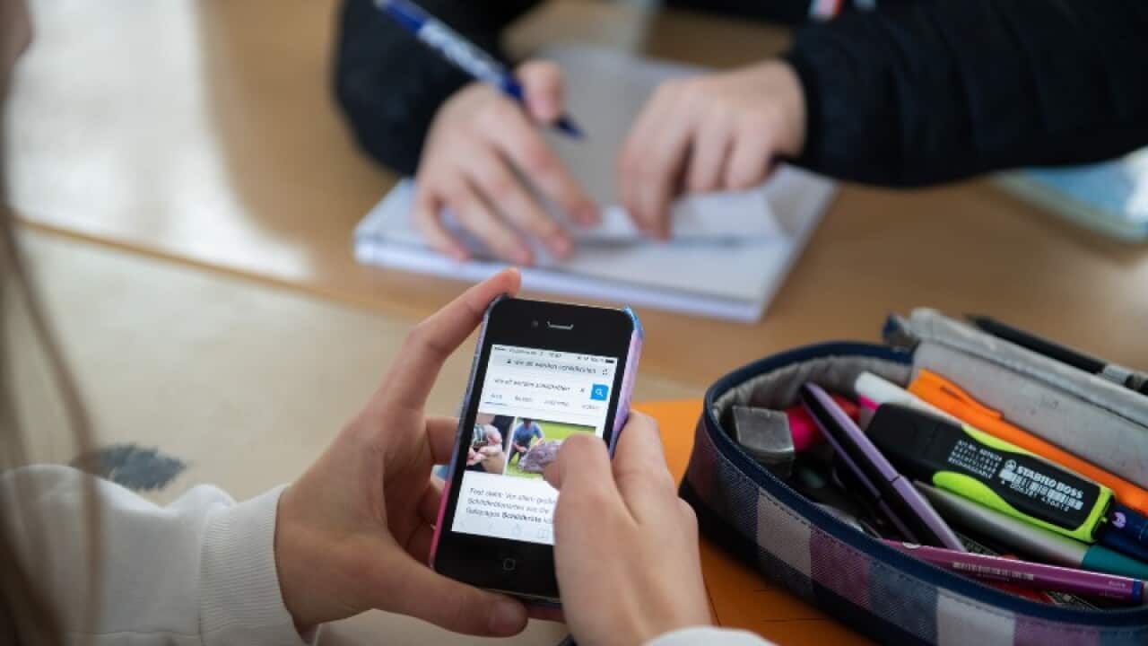 Students using a mobile phone (Getty Images).