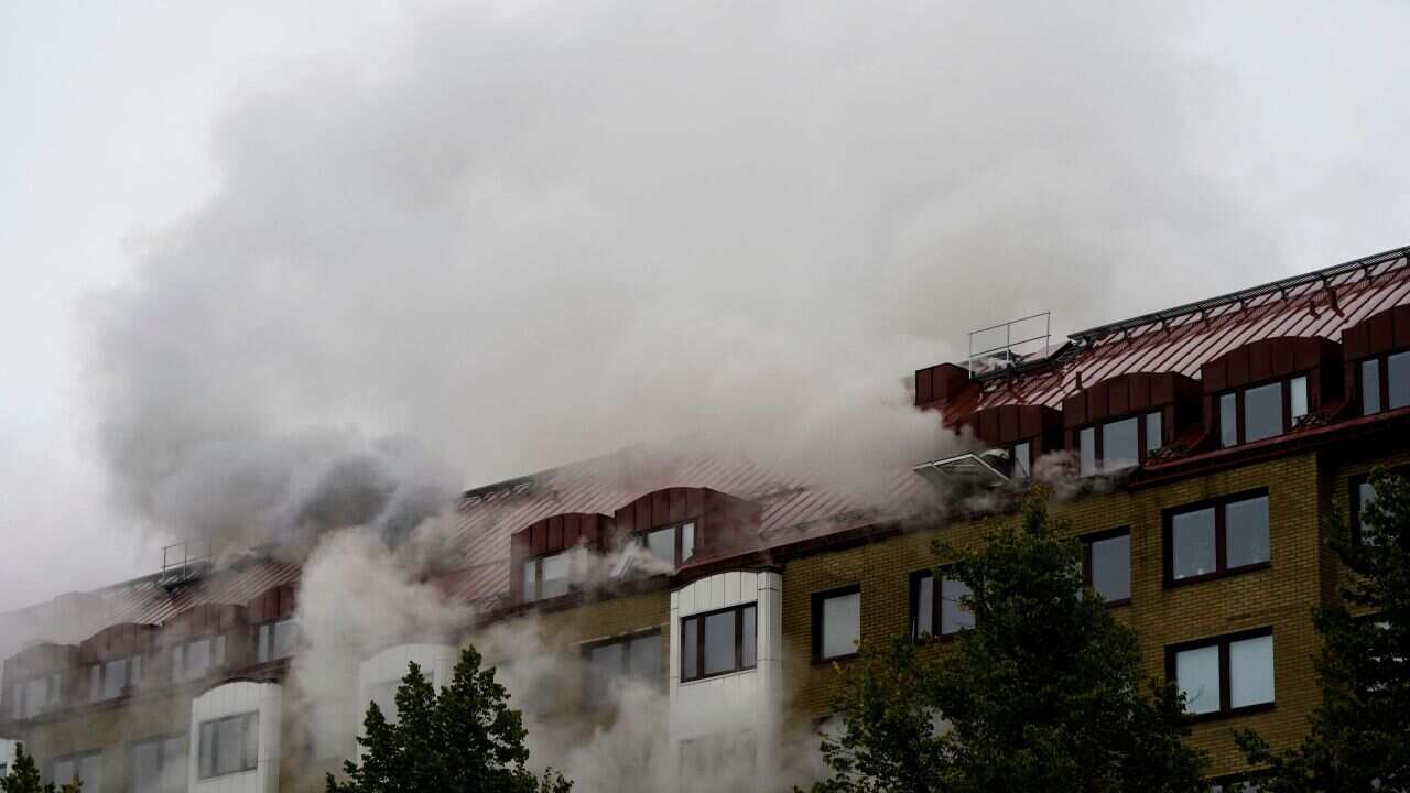 Smoke billows from a building as emergency services fights a fire at the site of an explosion in central Gothenburg on September 28, 2021.