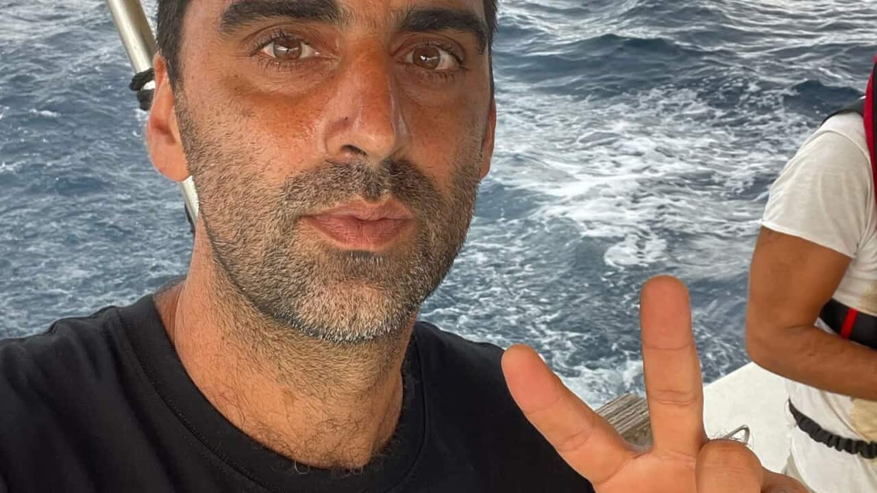 رجل يرتدي قميصًا أسود على متن سفينة ينقر على صورة سيلفي.