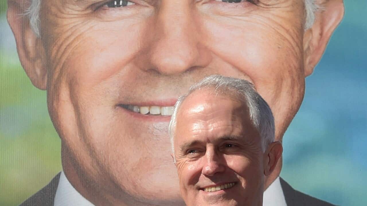 Malcolm Turnbull in front of a giant bilboard of himself in Adelaide