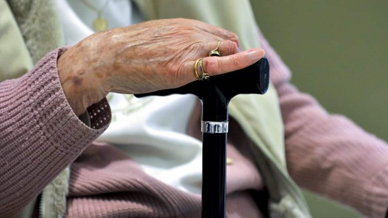 A woman uses a walking stick to assist her mobility in Canberra, Friday, May 24, 2013. (AAP Image/Alan Porritt) NO ARCHIVING