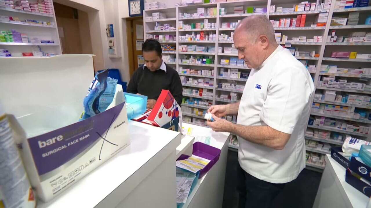 Pharmacist Nick Logan and one of his staff at his Artarmon chemist (SBS).jpg