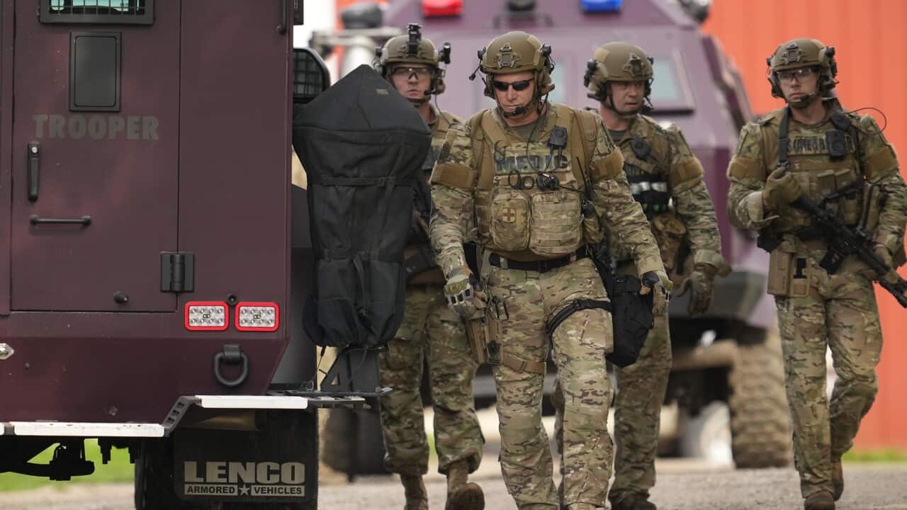 Members of law enforcement agencies search for shooting suspect, Vance Boelter (AAP)