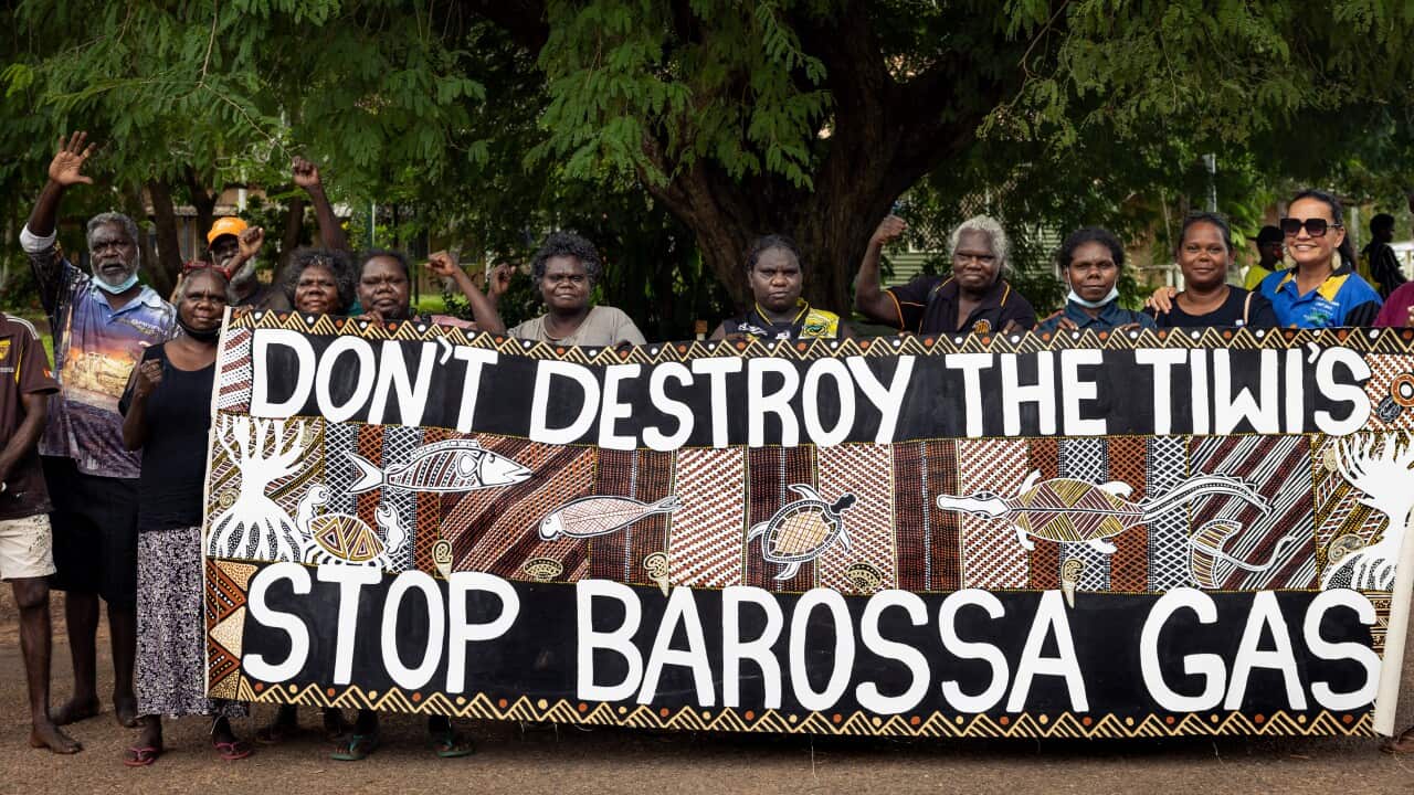 Tiwi islanders hold a sign protesting the barossa gas project