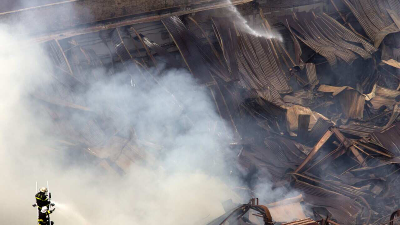 Firefighters work to extinguish a fire at a warehouse