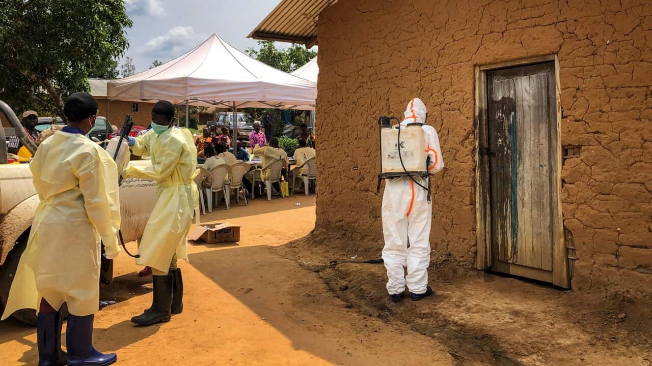 A worker from the World Health Organization decontaminates the doorway of a house in the village of Mabalako, in eastern Congo last month.
