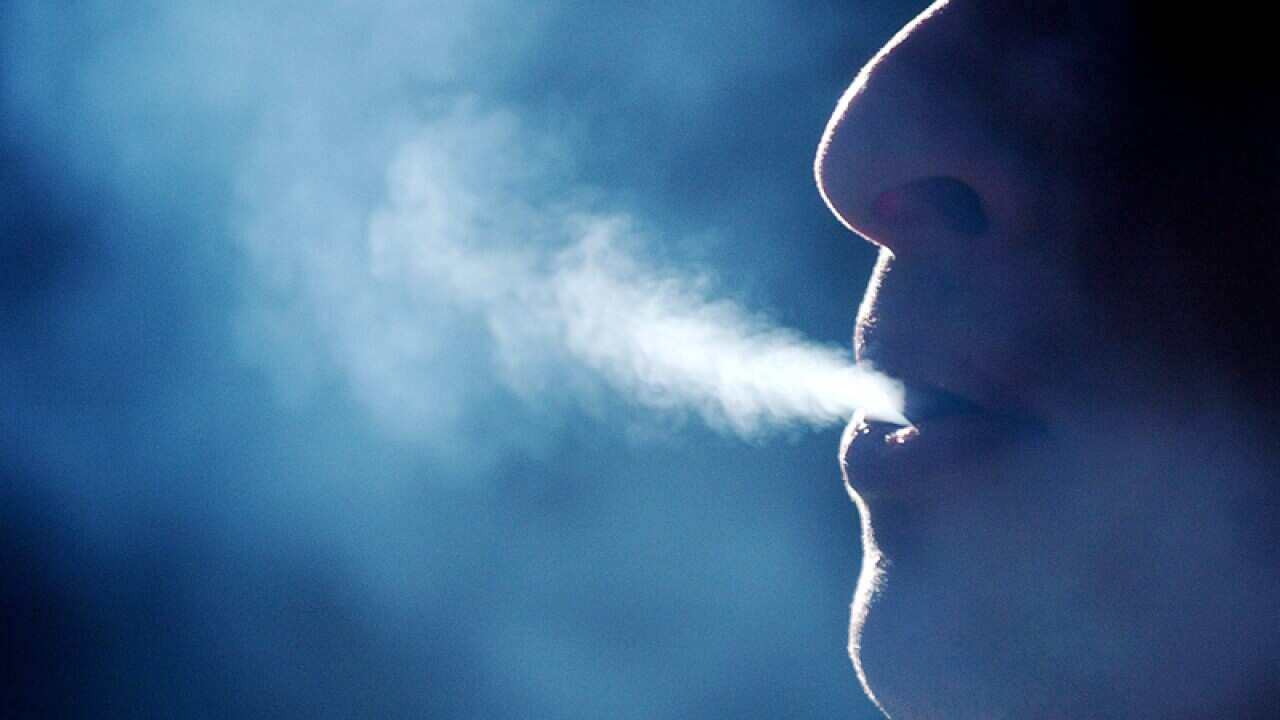 Man blows out smoke.