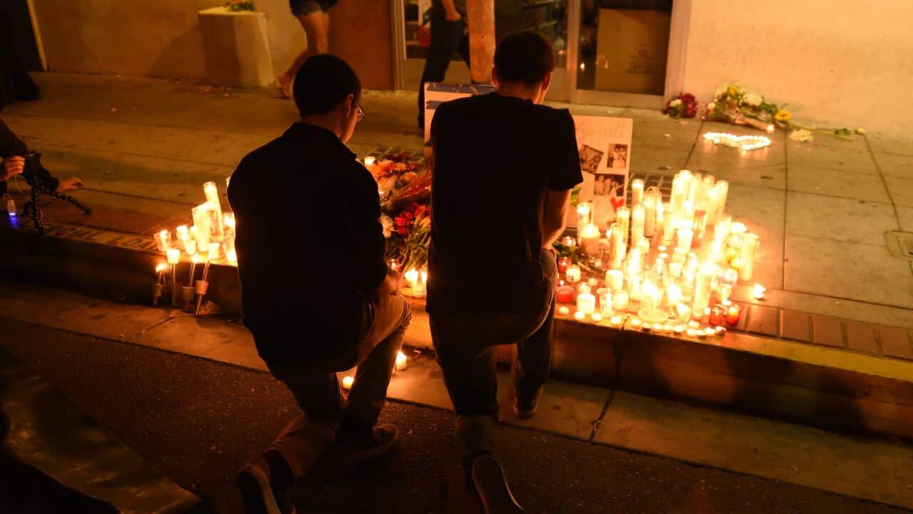 Two men kneel at a makeshift memorial after a killing rampage May 24, 2014 left seven people dead, in Isla Vista near Santa Barbara California May 24, 2014. (AAP)