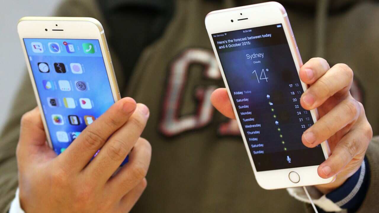 A person holds two iPhones