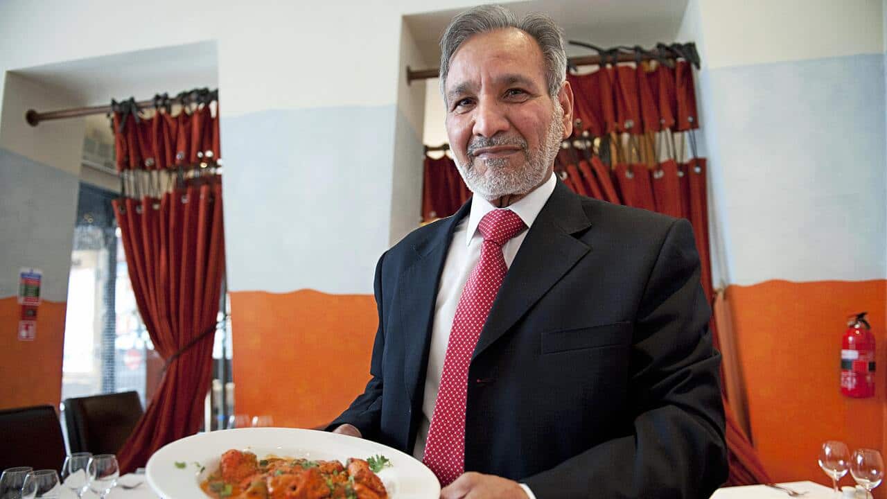 Ahmed Aslam Ali, pictured with a plate of chicken tikka masala in his restaurant.