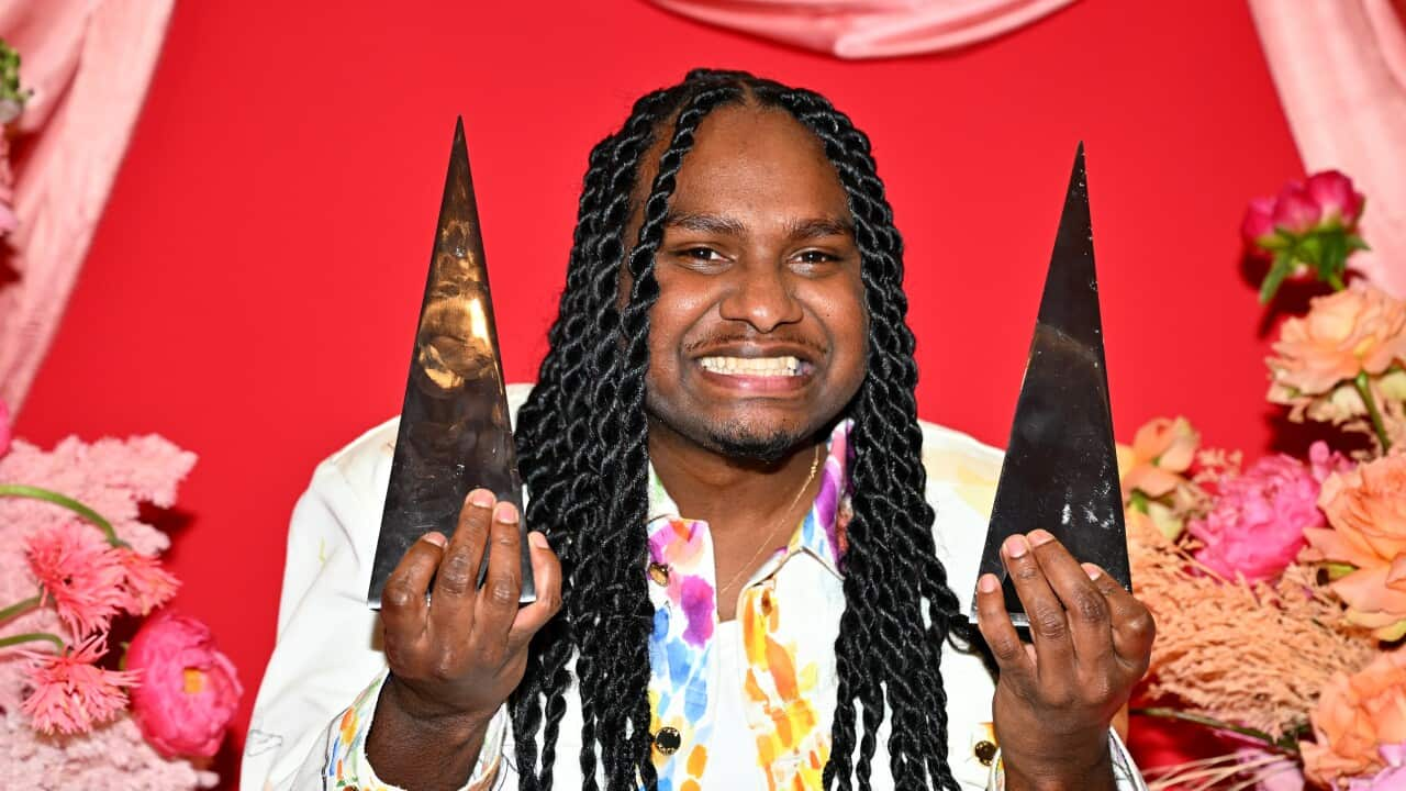 Baker boy holding two ARIA awards