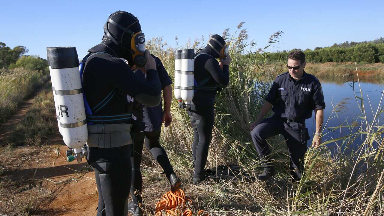 Members of the police dive unit prepare to search an irrigation channel for the body of teacher Stephanie Scott on the outskirts of Leeton, in the NSW Riverina, Friday, April 10, 2015. (AAP Image/David Moir) NO ARCHIVING