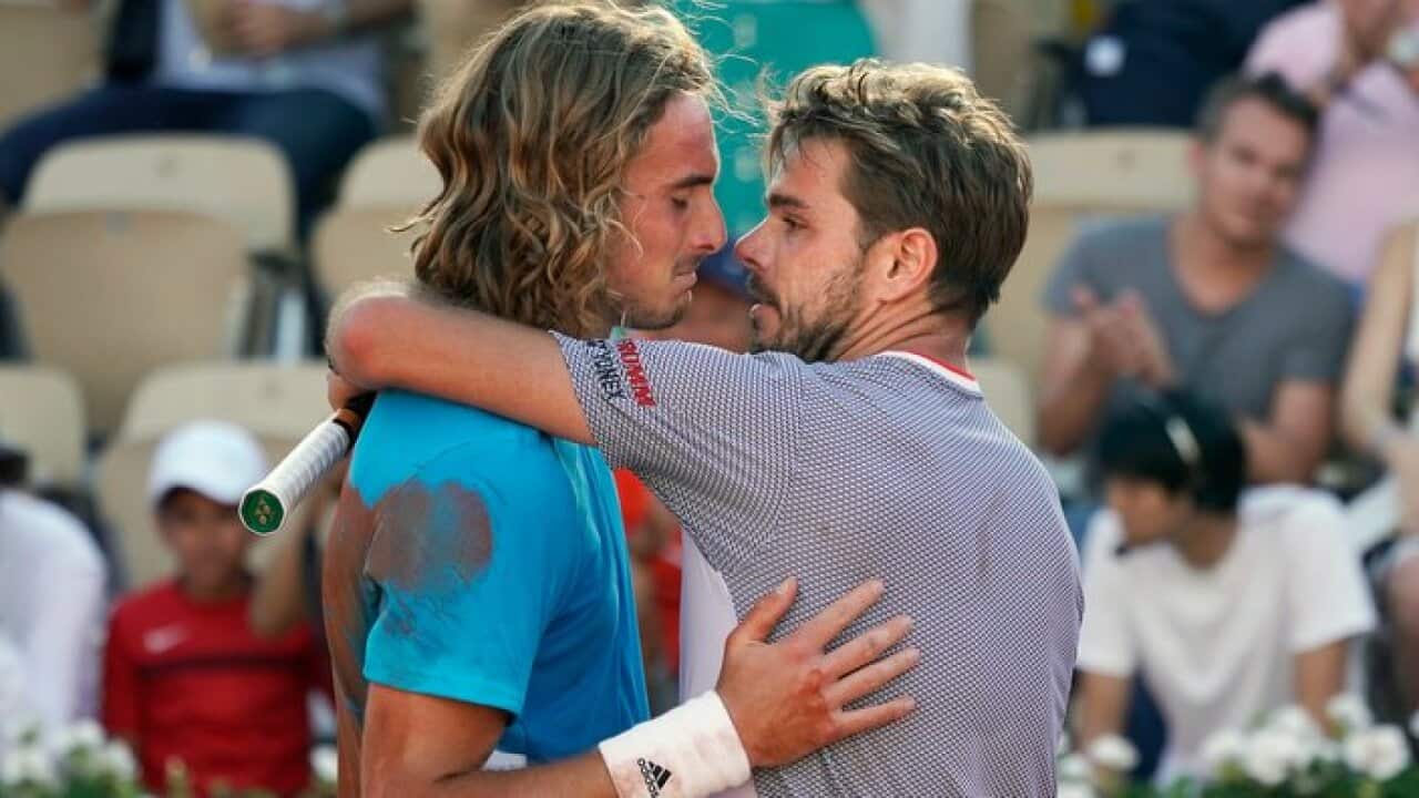 Stan Wawrinka (R) and Stefanos Tsitsipas hug after their round 4 marathon match at the French Open in Paris on June 2, 2019.