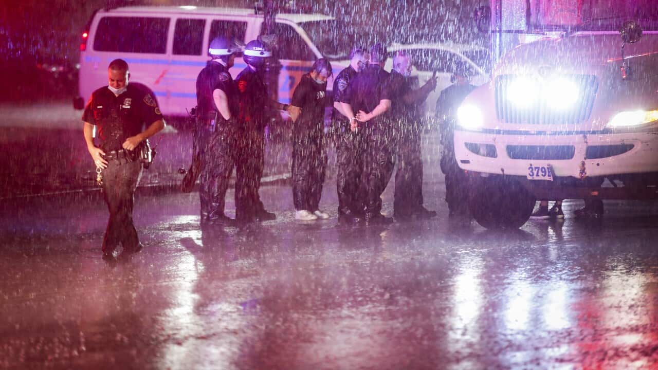 Protesters are arrested in the rain by New York Police Department officers for violating curfew.