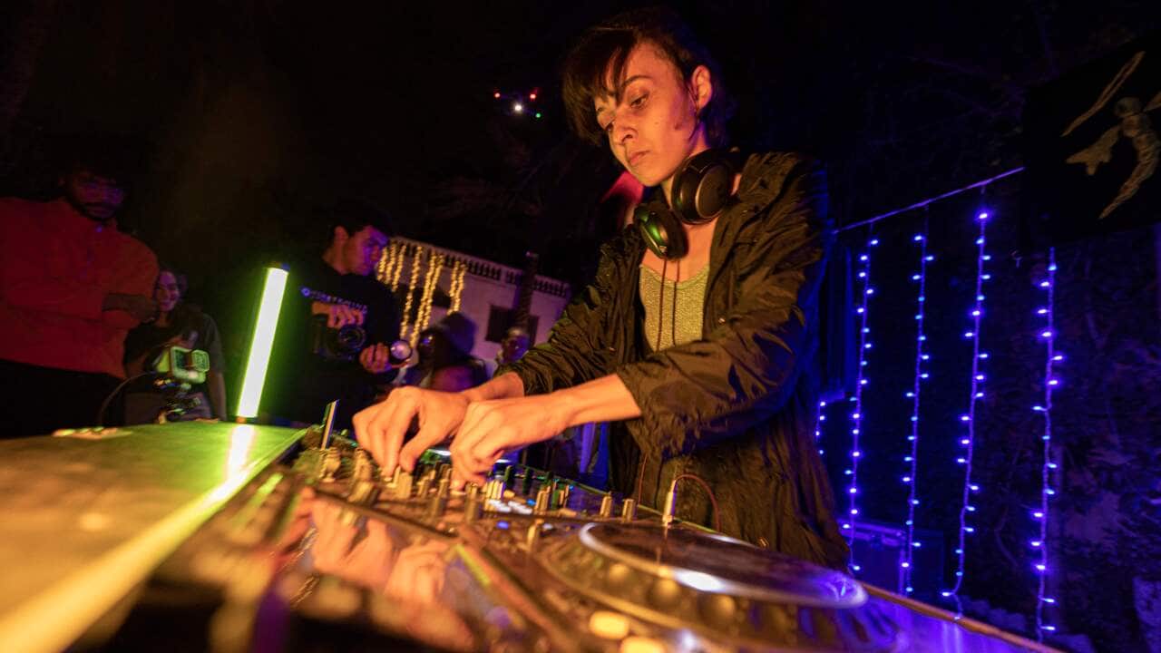 A woman operating audio equipment at a concert.