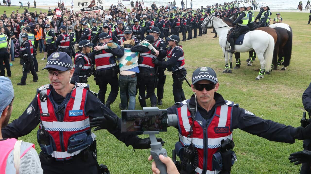 Police on keep protesters apart as a man is arrested on the St Kilda foreshore in Melbourne, Saturday, January 5, 2019.
