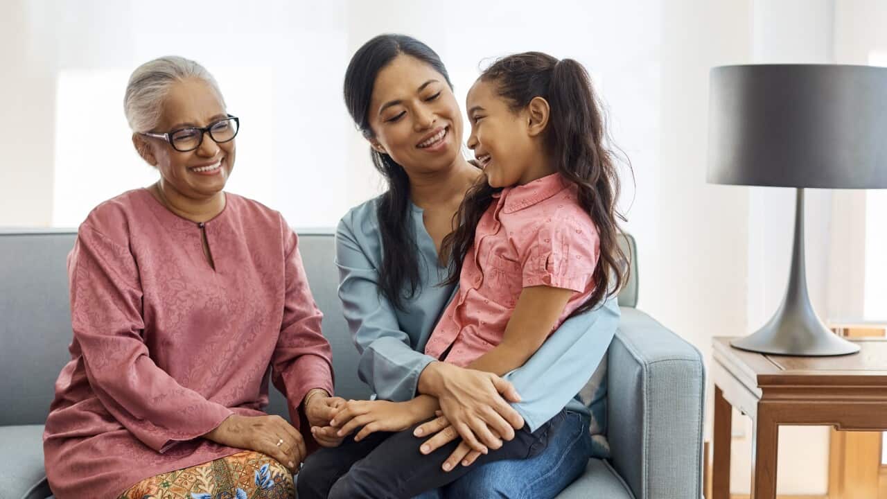 Smiling multi-generational family sitting at home