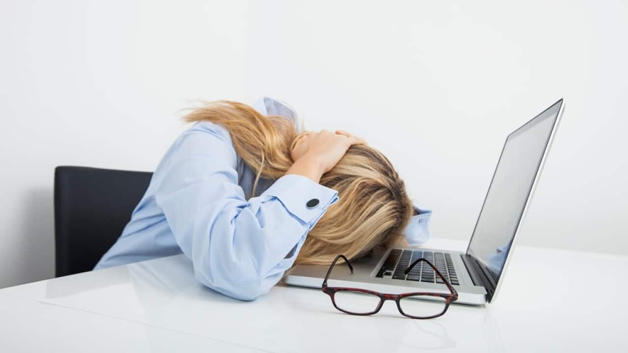 Tired businesswoman resting head on laptop in office