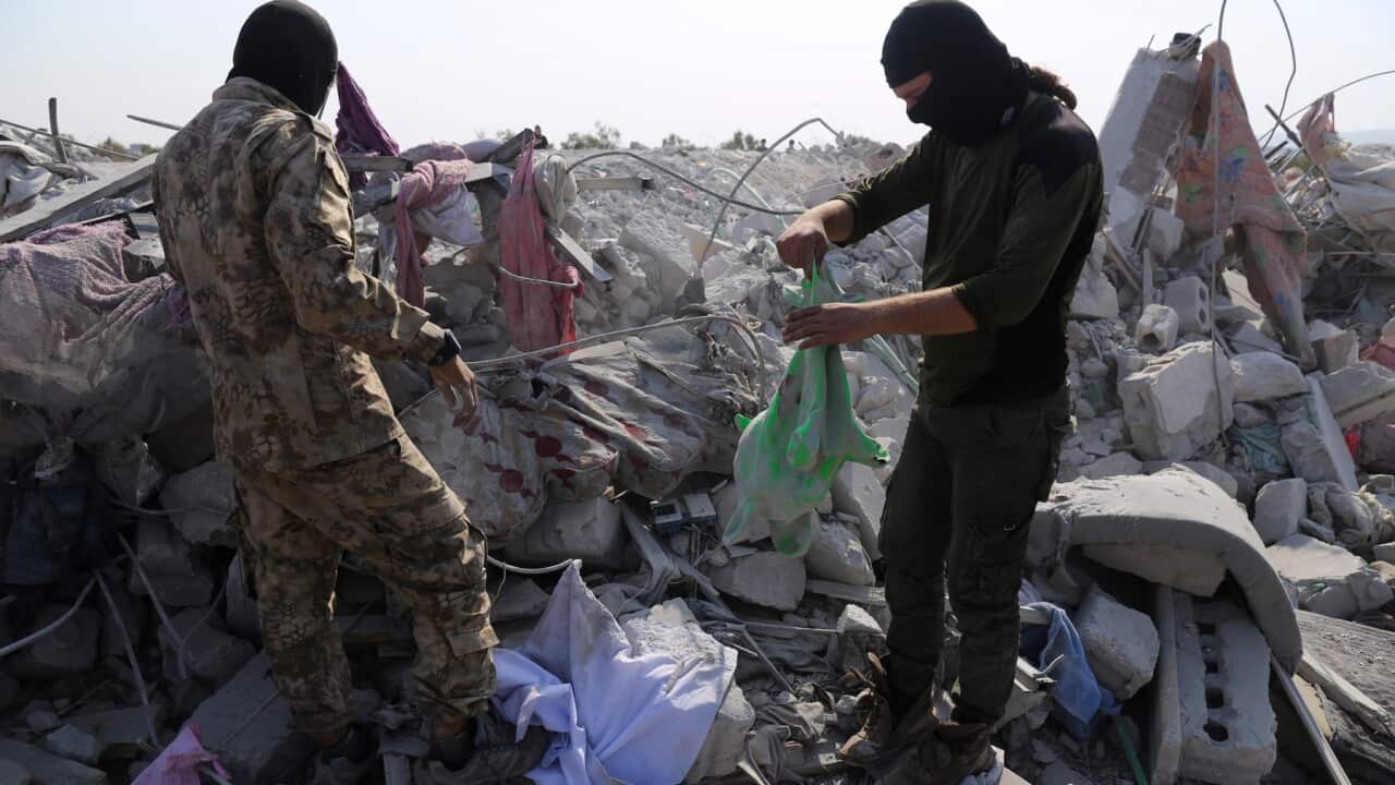 People look at a destroyed house in Idlib province after the US operation targeting Abu Bakr al-Baghdadi