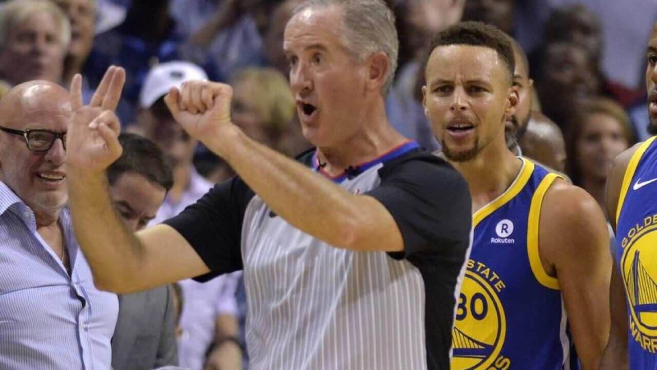Referee Scott Wall (L) calls Golden State's Stephen Curry for a foul