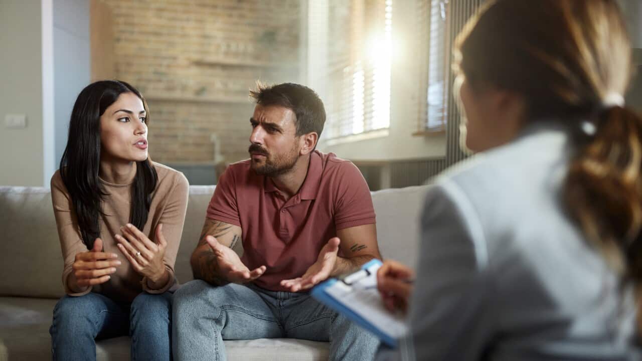 Displeased couple having a counseling session with therapist.