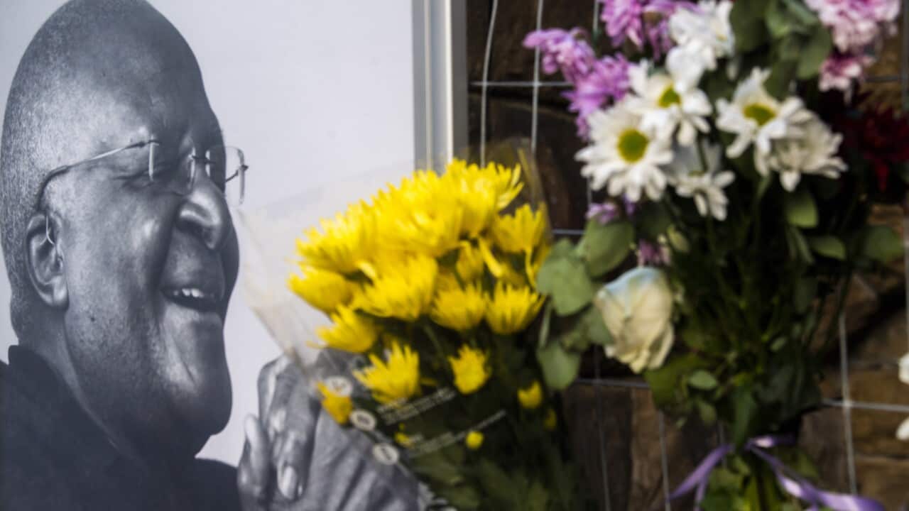 Flowers are posted alongside a photo of Anglican Archbishop Desmond Tutu at the St. Georges Cathedral in Cape Town, South Africa, Sunday, Dec. 26, 2021