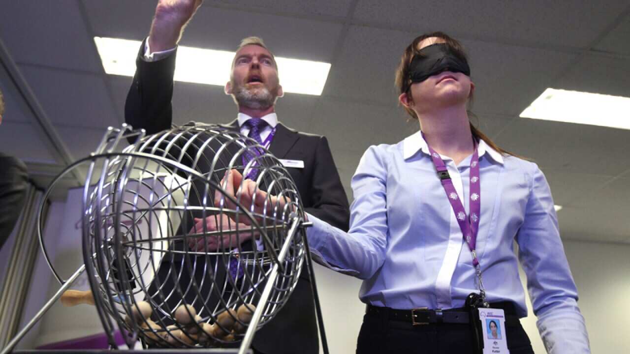 A blindfolded member of the AEC picks random numbers