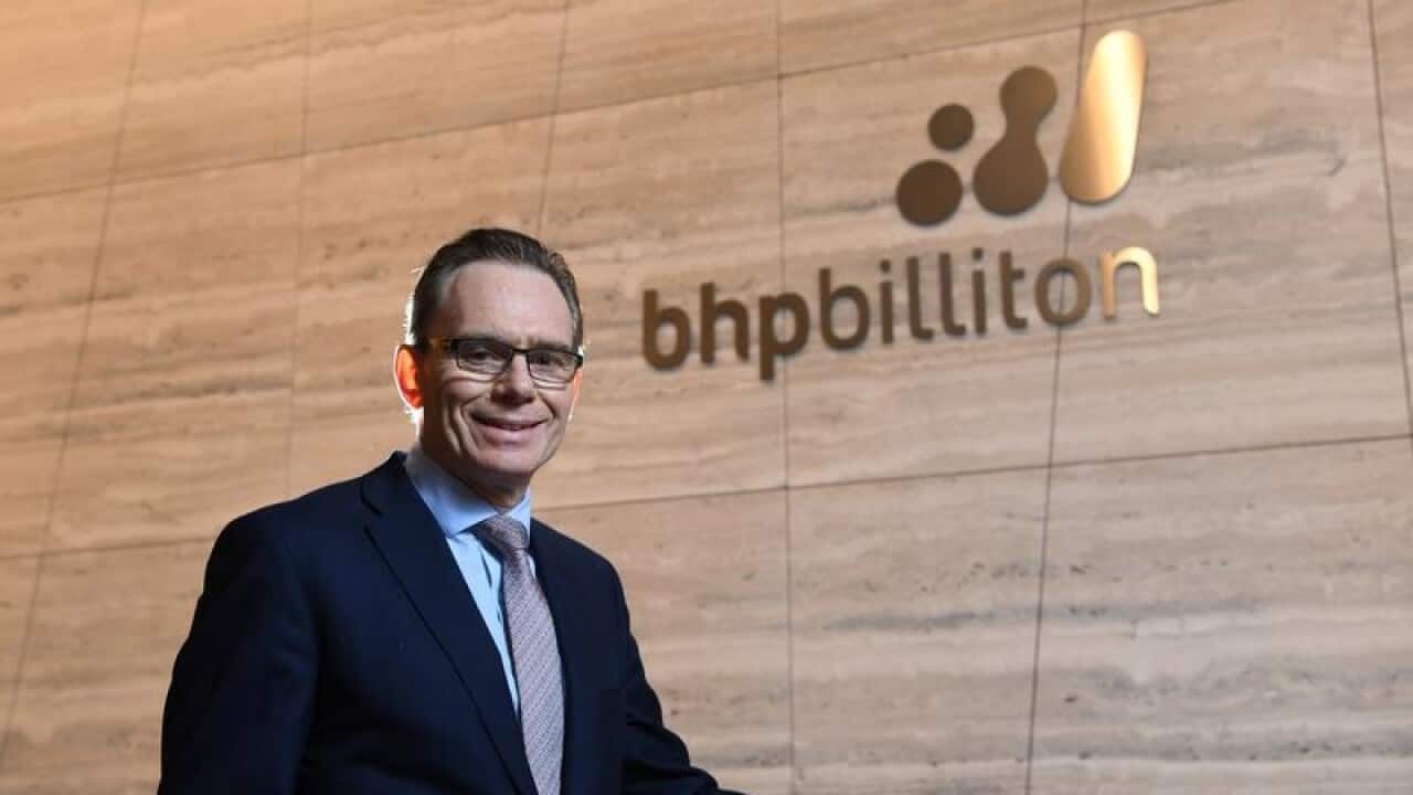 BHP CEO Andrew Mackenzie , standing in front of company logo on wall