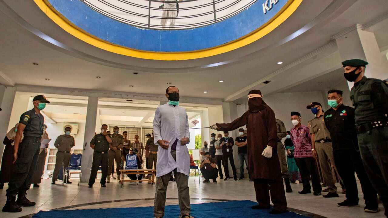A Sharia Law official uses a rattan cane to whip one of two men convicted of gay sex in Banda Aceh, Aceh province, Indonesia, on 28 January.