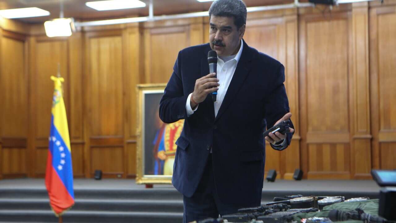 Venezuelan President Nicolas Maduro displaying seized armament and passports
