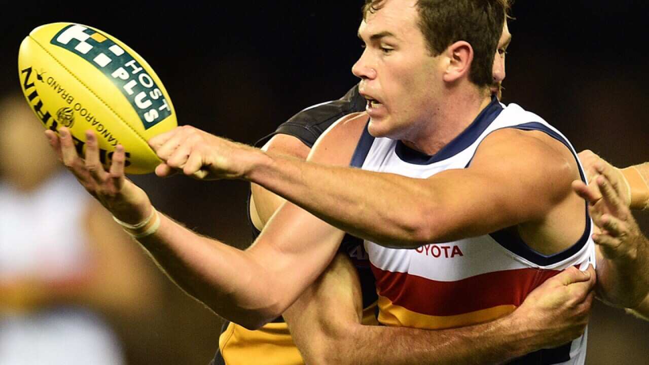 Mitch McGovern of the Crows handballs against Richmond
