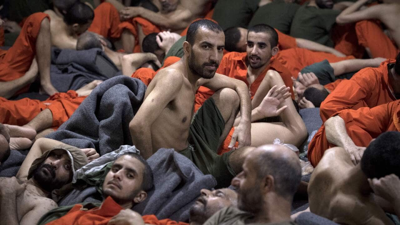 Men accused of being affiliated with ISgroup, sit on the floor in a prison in the northeastern Syrian city of Hasakeh on October 26, 2019. 