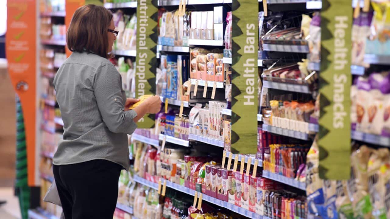 An employee puts price tags on products at a supermarket