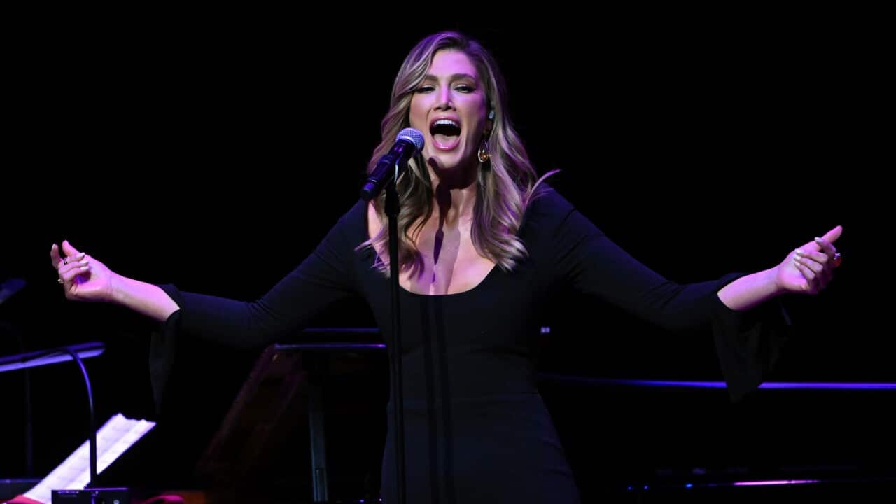 Delta Goodrem singing a medley of Olivia Newton-John's hits at a state memorial in Melbourne