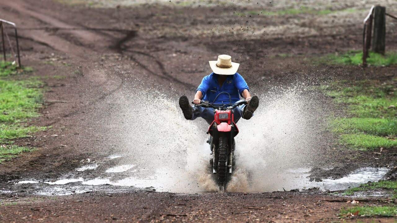 Farmer on a bike, enjoying the rain