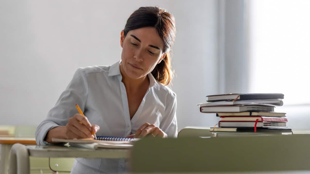 Adult woman going back to school and writing in her notebook