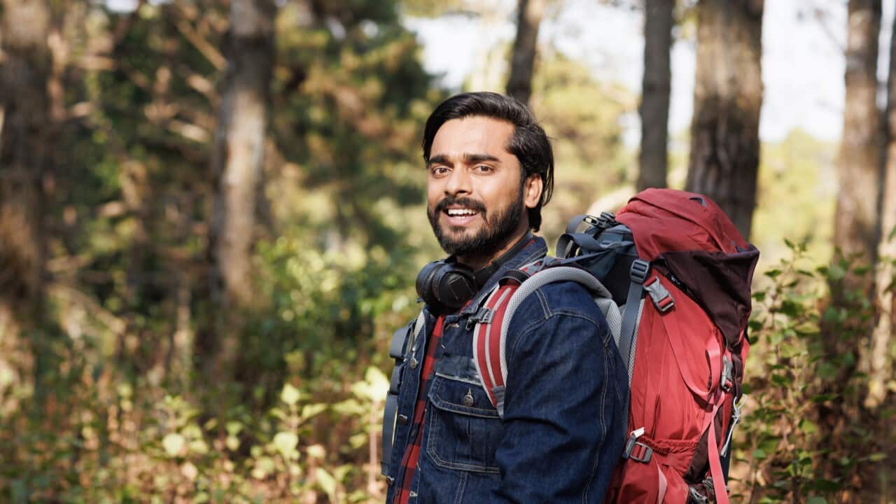 Portrait Young India man backpack smile in forest