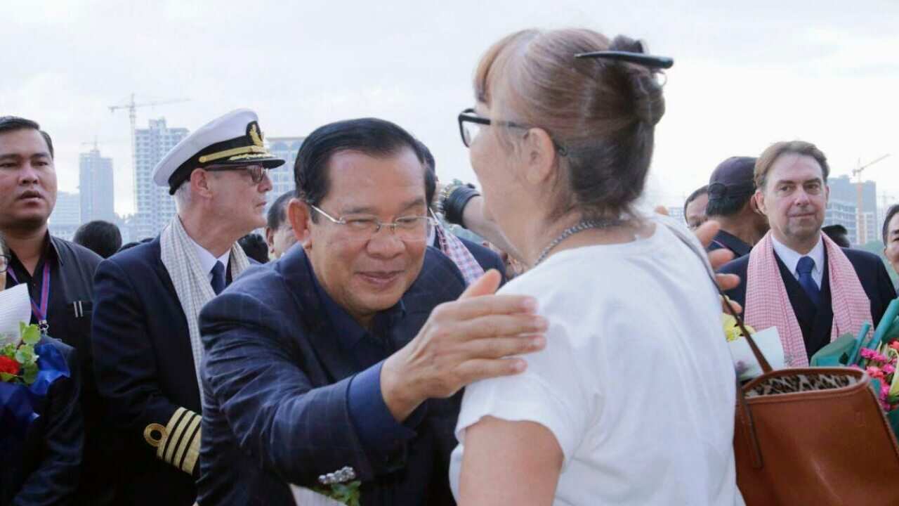 Cambodian Prime Minister Hun Sen (C) greeting a passenger of the Westerdam cruise ship that was turned away from at least five ports over coronavirus fears.