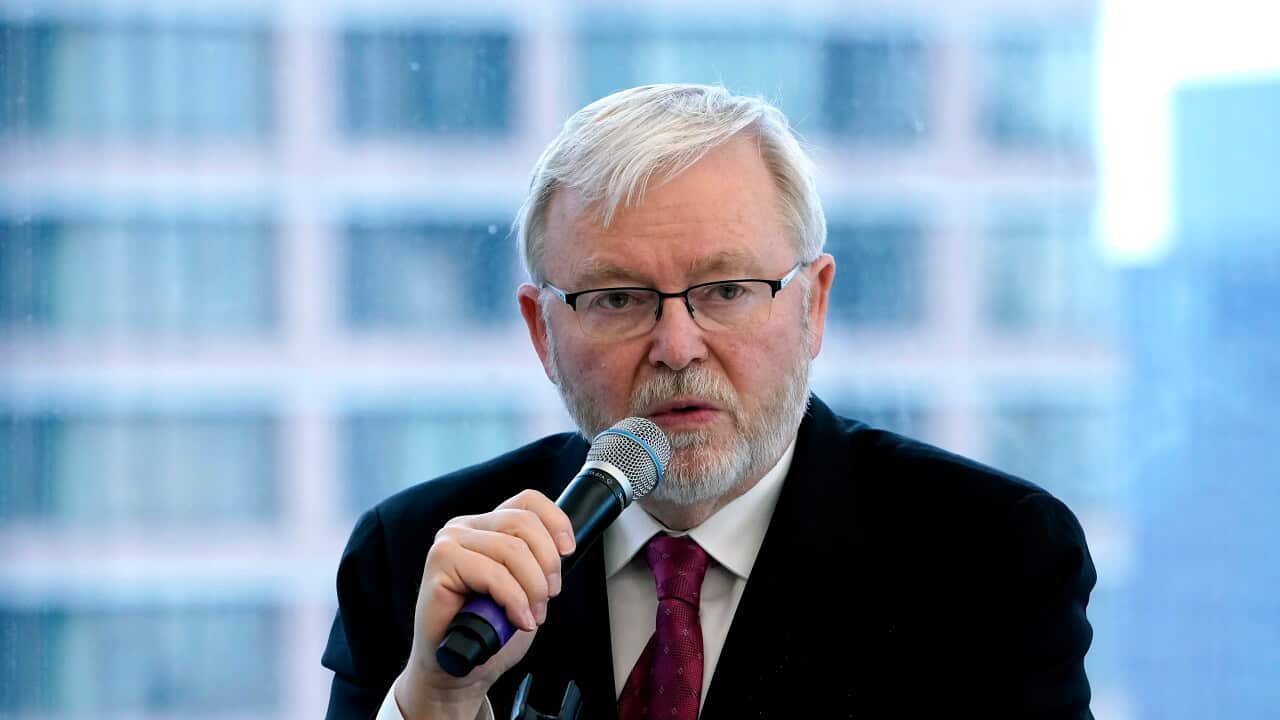 Kevin Rudd, wearing a suit and tie, speaking into a microphone.
