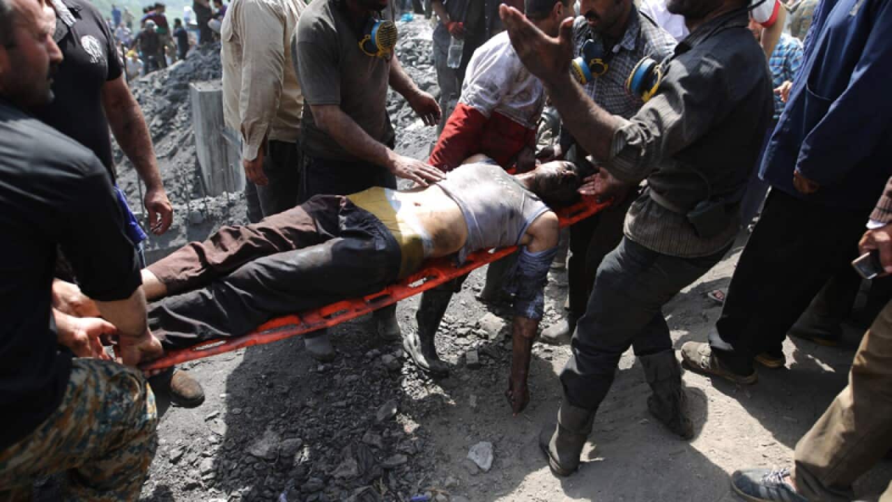 Emergency personnel and mine workers carry an injured coal worker