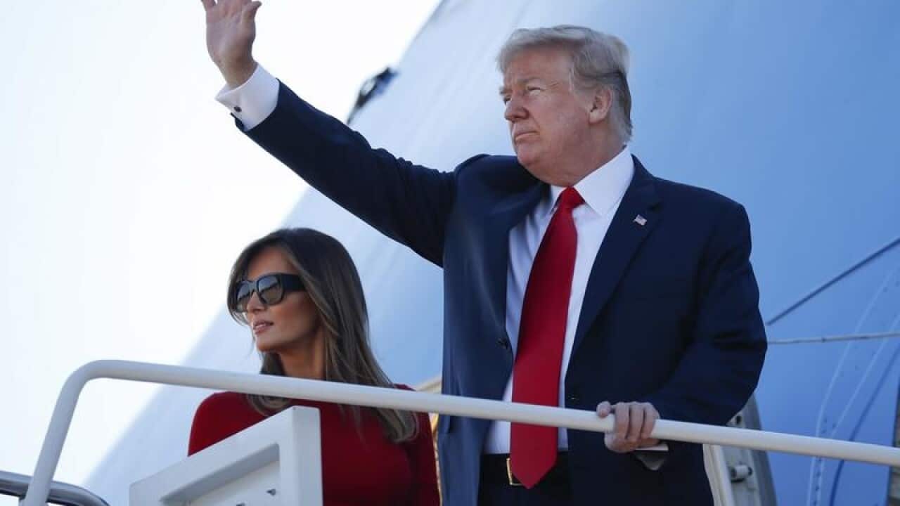 President Donald Trump waves onboard Air Force One
