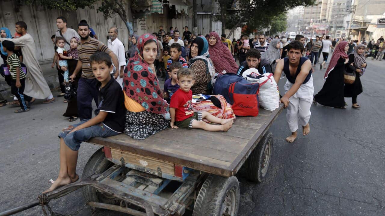Palestinians flee homes in Gaza's eastern Shejaiya district after Israeli shelling (AAP)
