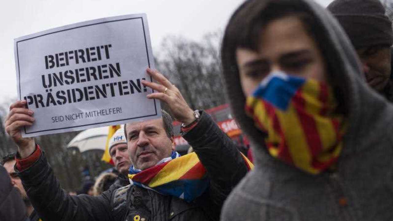 A man holds a poster reading: 'Free our President ' during a protest condemning the arrest of Catalonia's former leader Carles Puigdemont in Germany, at a demonstration in Berlin, Germany, Sunday, April 1, 2018.