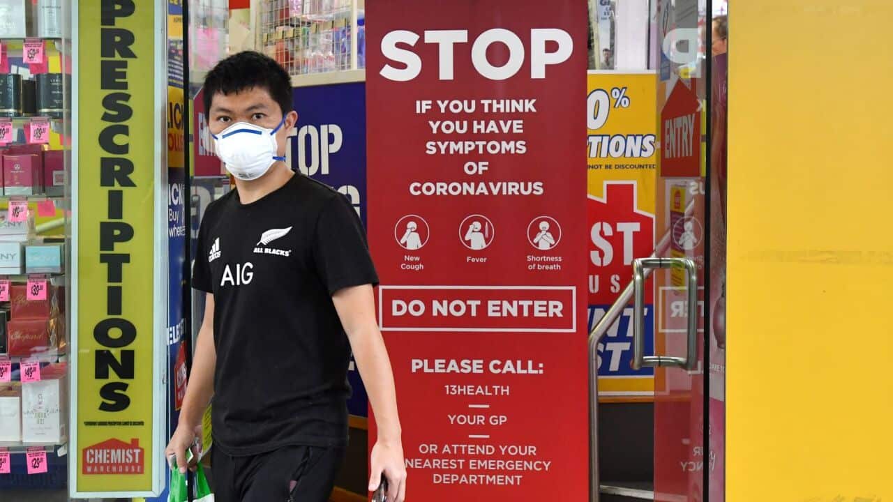 A customer wearing a protective face mask is seen leaving a Brisbane pharmacy